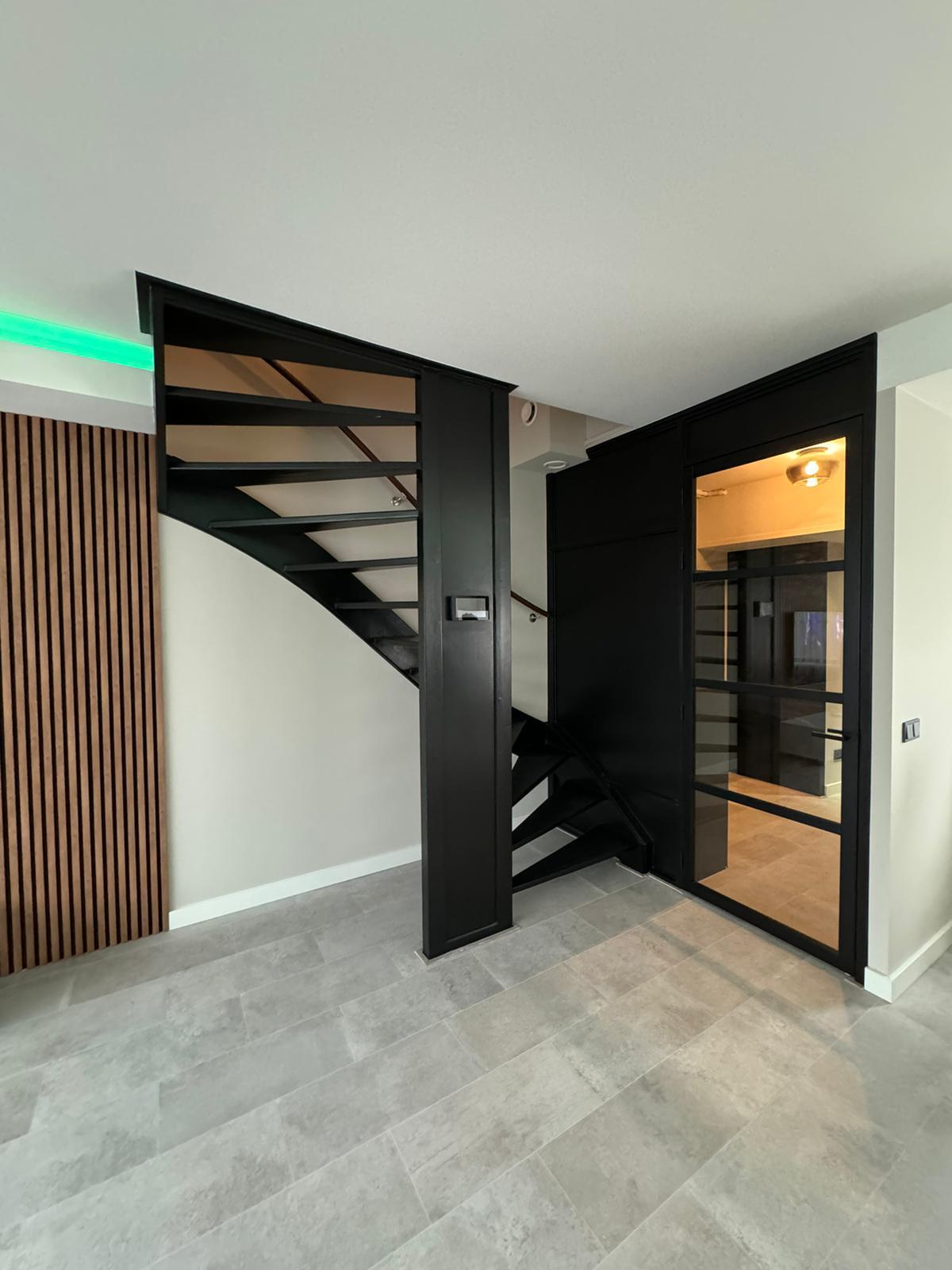 Interieur renovatie met pivotdeur en lamellenwand